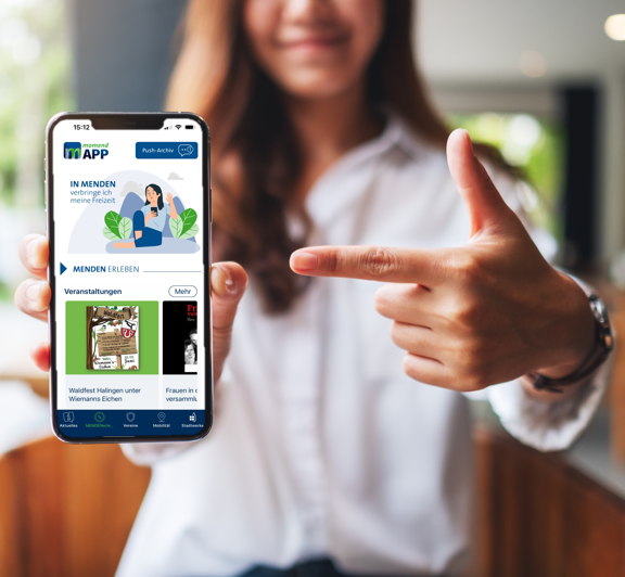 Frau zeigt auf Smartphone mit geöffneter Momend-App der Stadtwerke